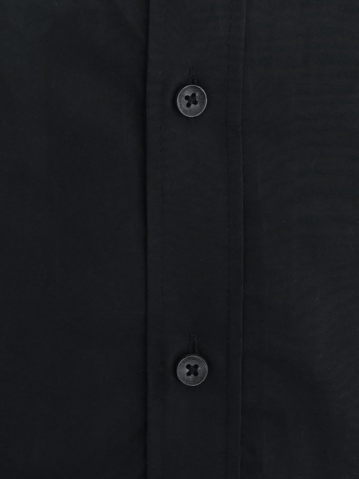 Close up of yellow ribbon accent on black cotton shirt