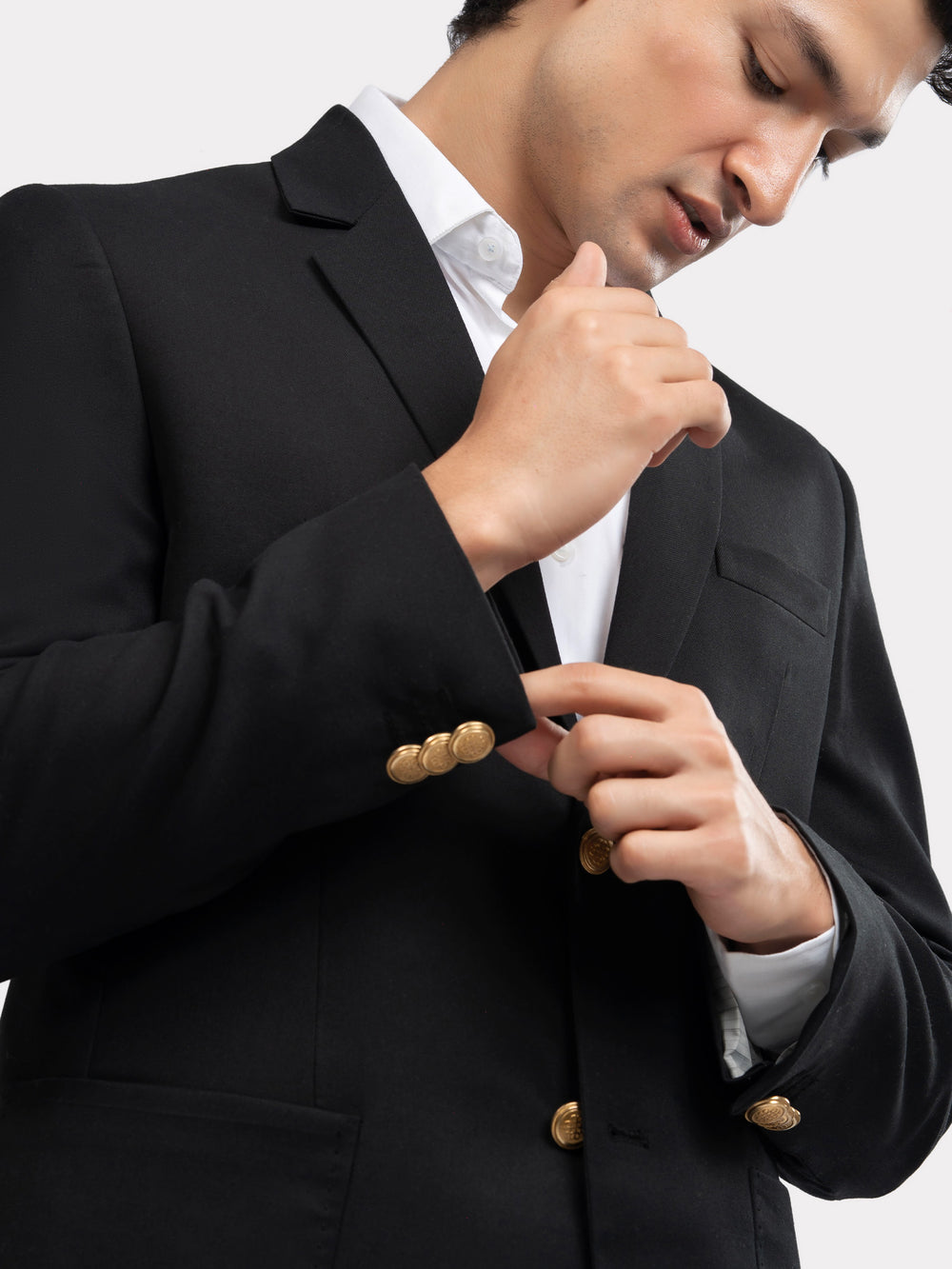 Close up of golden buttons on black poly viscose blazer