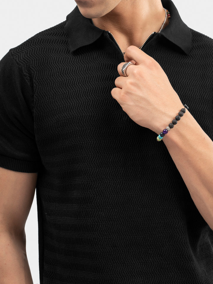 Close-up of front zipper detail on black cotton polo
