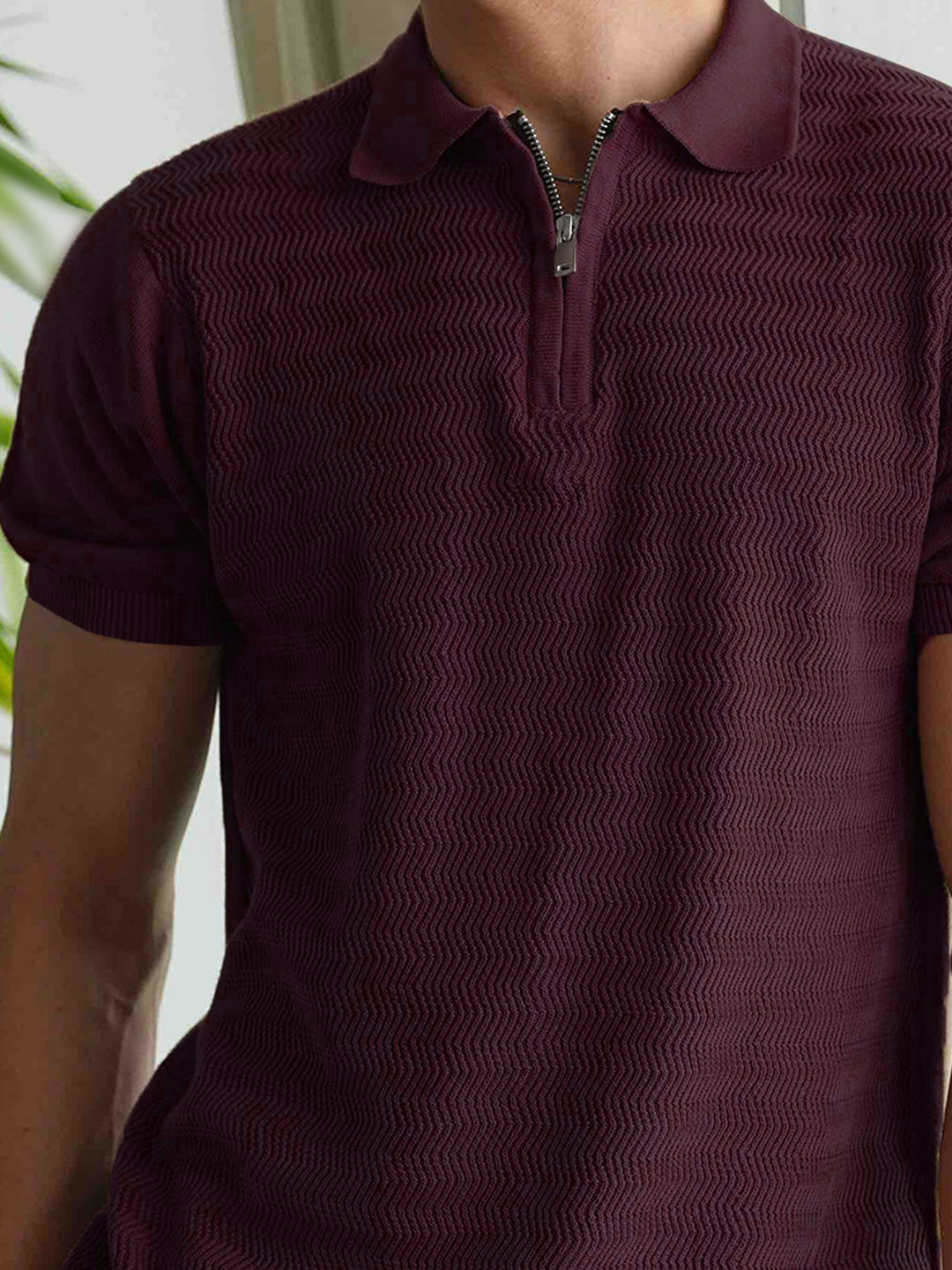 Close-up of front zipper detail on burgundy cotton polo