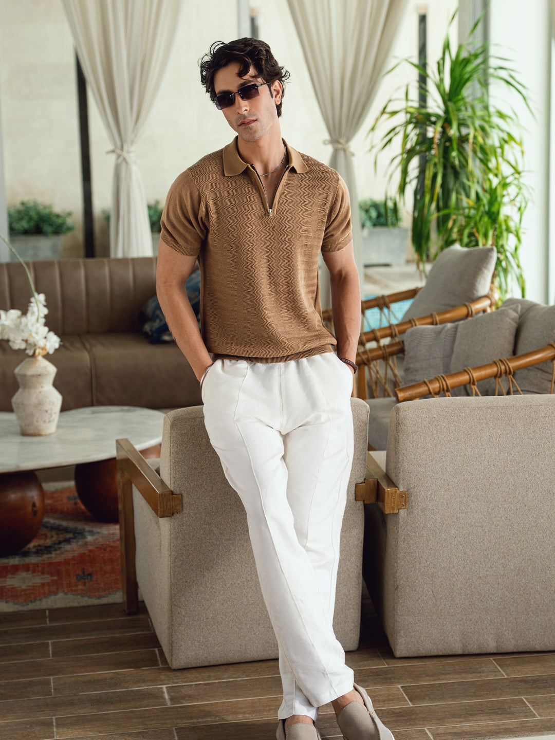 Man wearing the mid brown zip neck polo with casual trousers